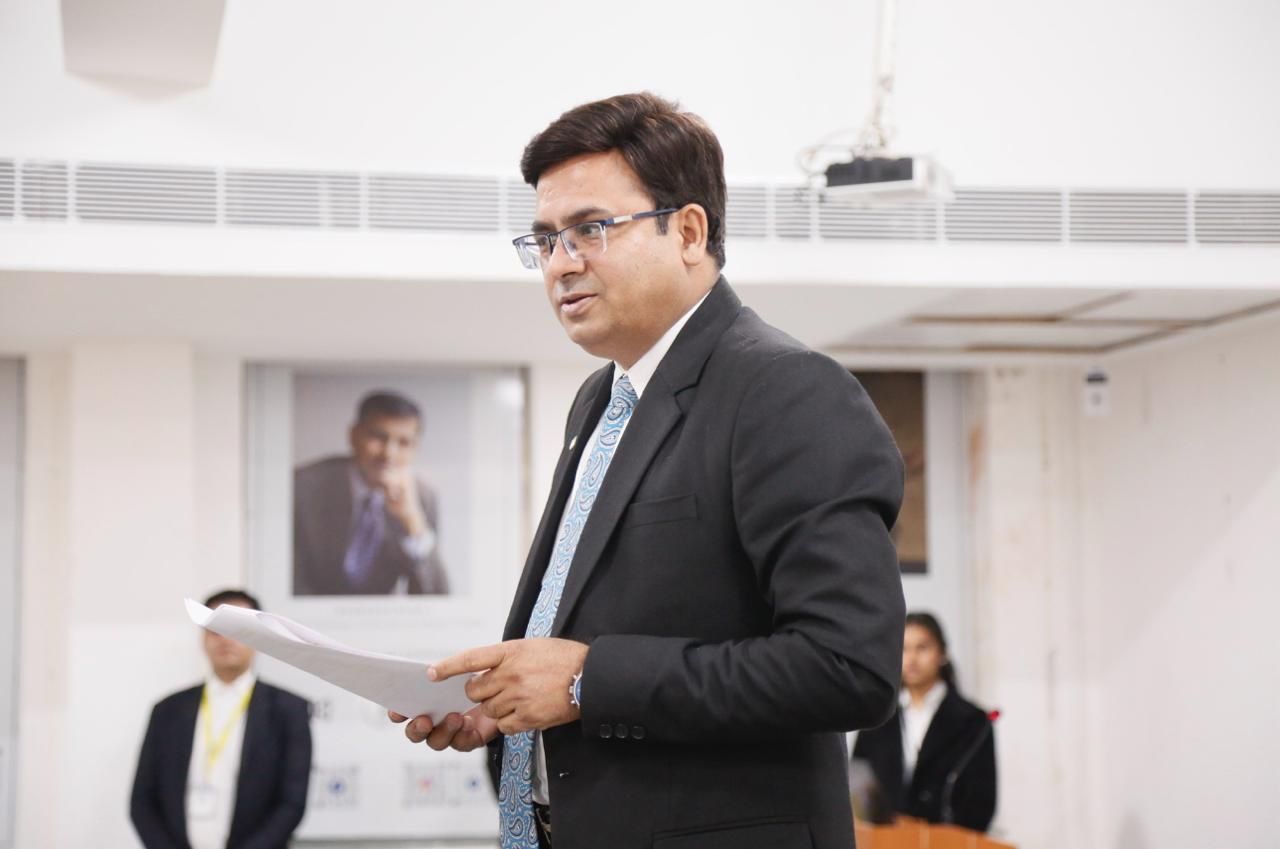 Dr Ajay Rana delivering a speech at a podium